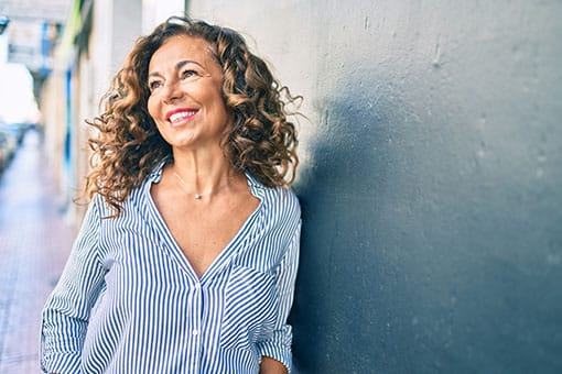 Middle Aged woman smiling with a dental implant bridge in Auburn Hills, MI.